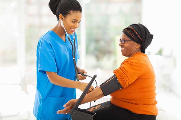 female medical worker checking womans blood pressure