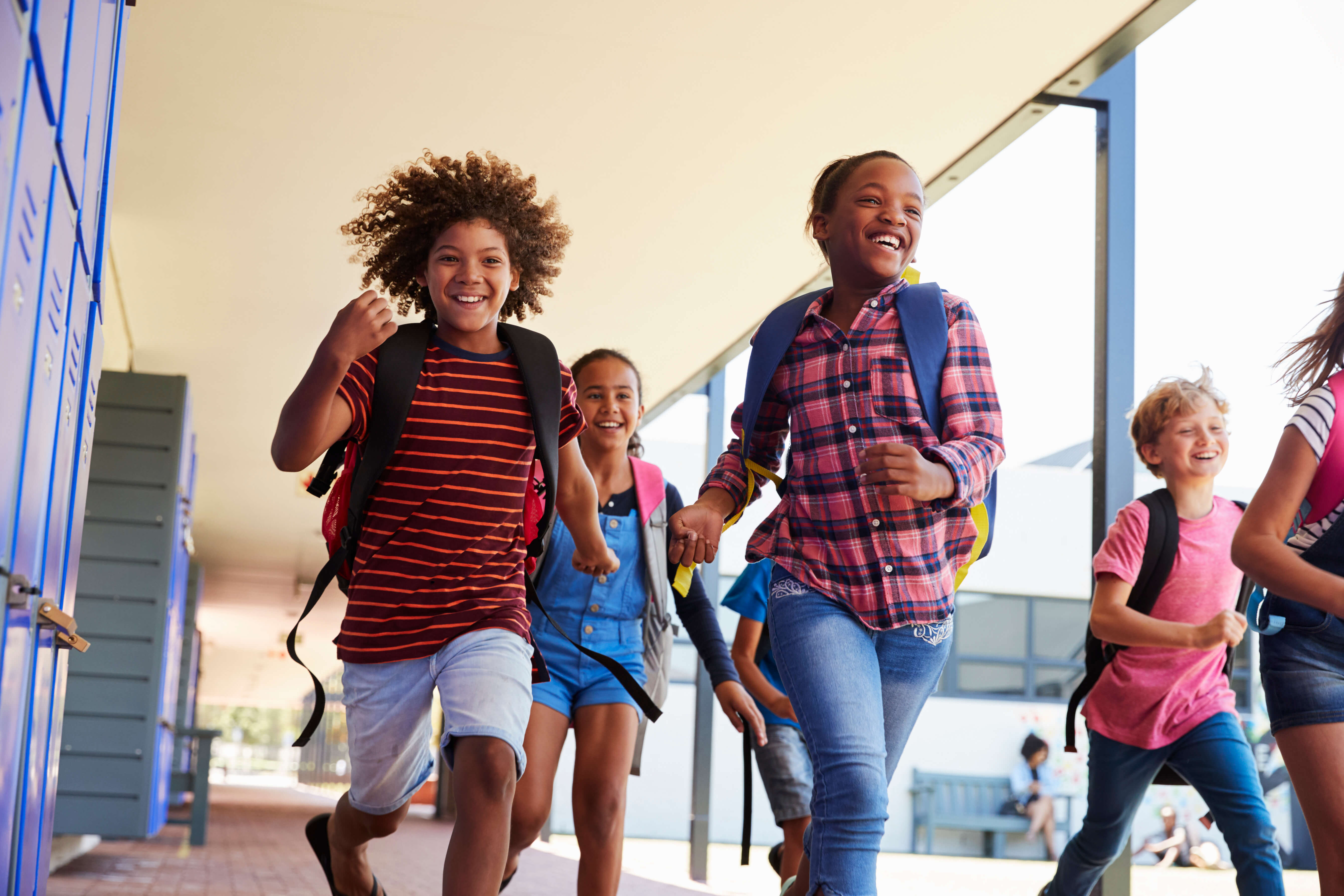 School kids running to camera in school hallway