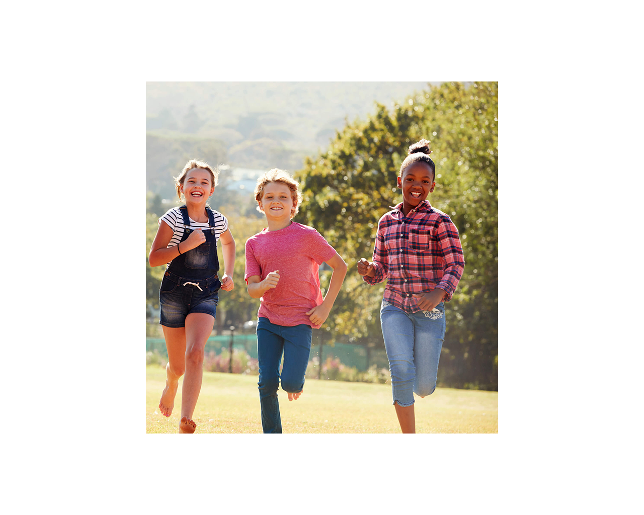 Three children in a park running toward camera