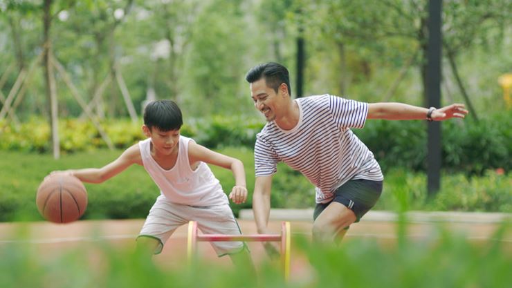 father and son playing basketball outdoors