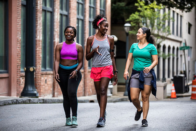 Group of female runners walking through urban area