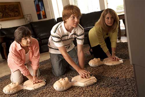 grandma and mom and son practicing hands only cpr in living room