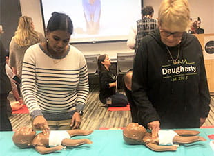 two women practicing infant cpr