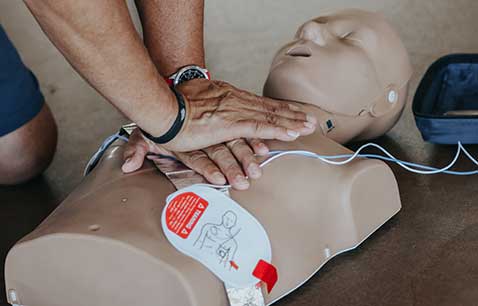 male hands performing cpr on cpr mannequin 