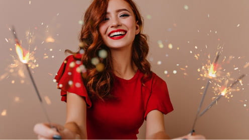 Woman wearing red and holding sparklers