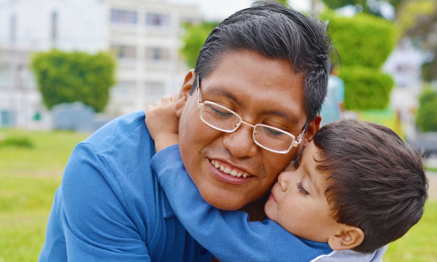 close up of young son hugging father