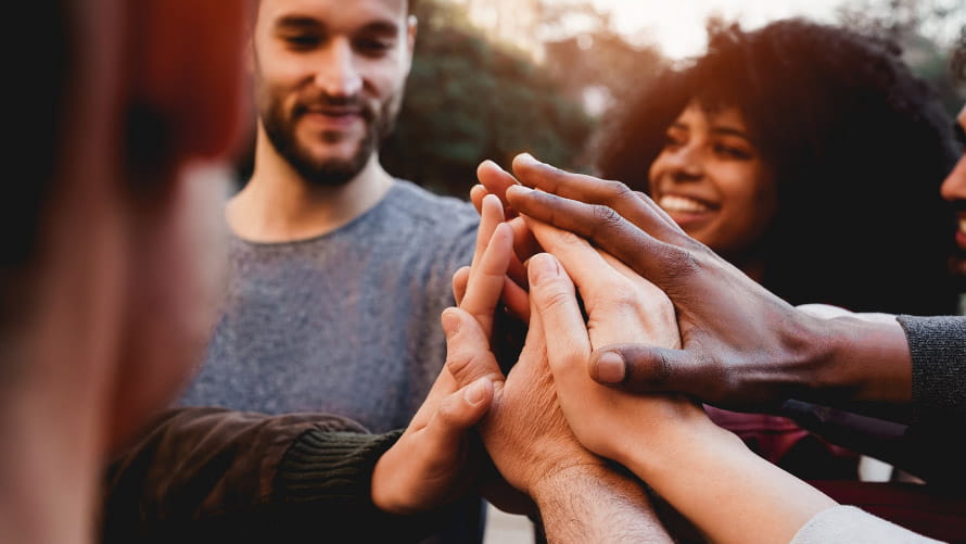 Group of people putting their hands together in a circle
