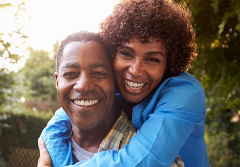 portrait of happy woman hugs husband from behind portrait of happy woman hugs husband from behind