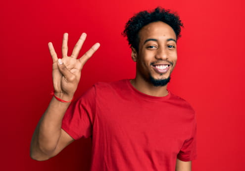 Man in red t-shirt holding up four fingers