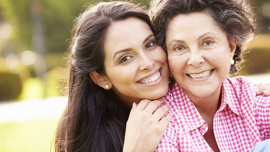 Mother and daughter smiling outdoors