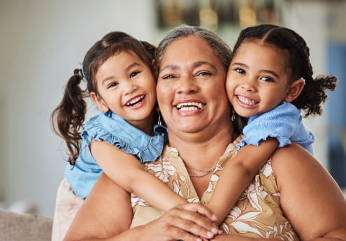 Woman and two children hugging and smiling