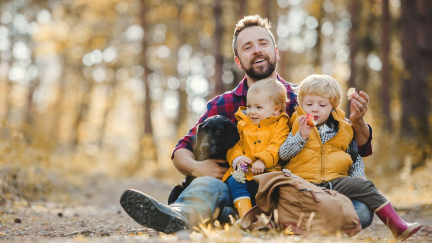 Man sitting with small children outside