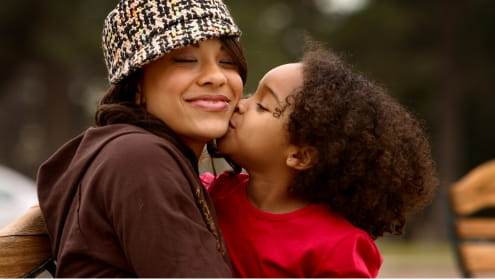 Young child kissing her mom on the cheek