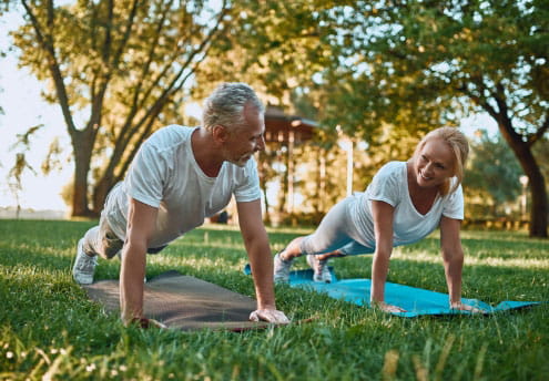 senior couple doing yoga outdoors