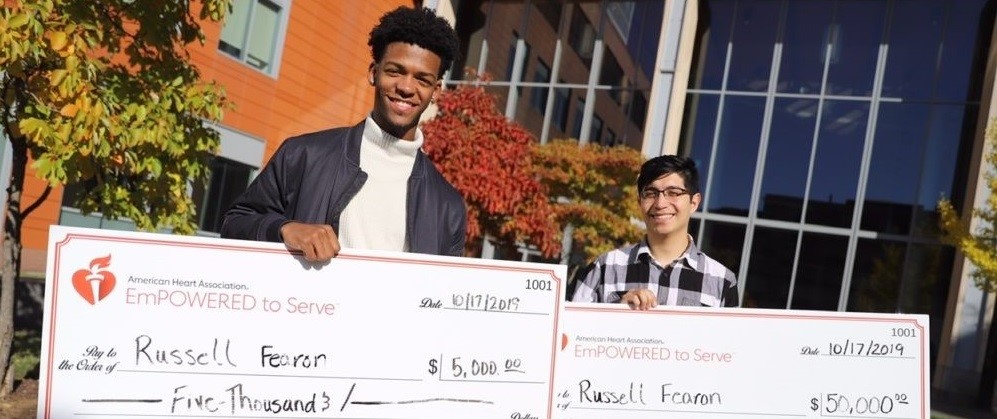 Russell Fearon and partner standing with the winning checks