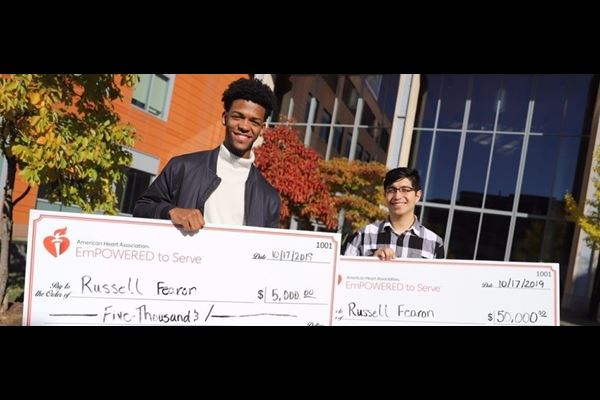 Russell Fearon and partner standing with the winning checks