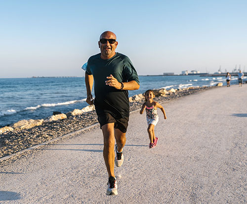 Father and daughter running on beach