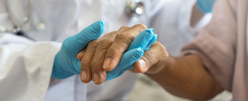 Medical professional holding hands with patient
