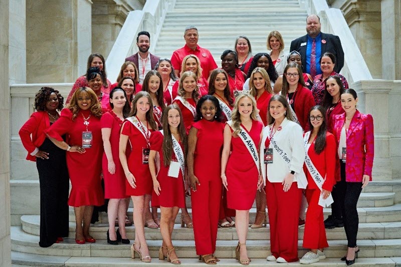 Group of women representing Miss America posing in front of steps