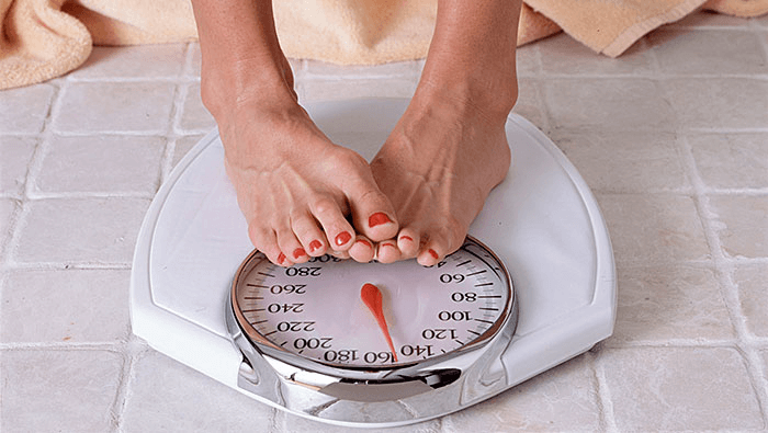 close up of woman's feet standing on a scale