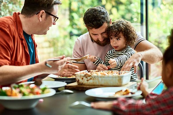 fathers feeding young children family dinner at home