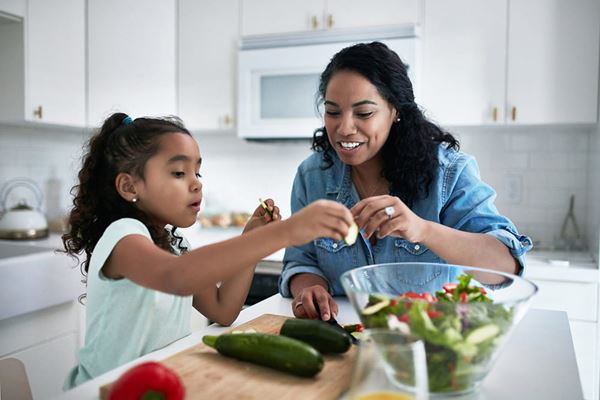 mom and daughter making salad