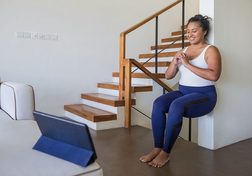 Woman doing strength exercises with back to the wall