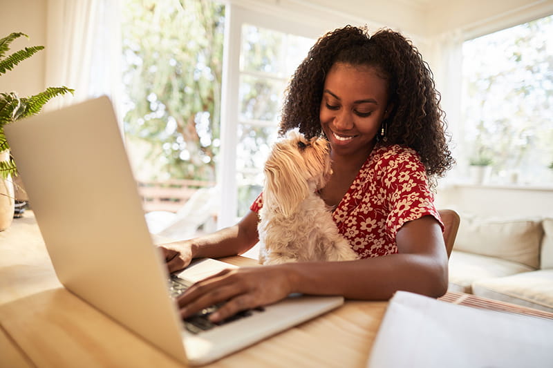 woman using laptop with dog