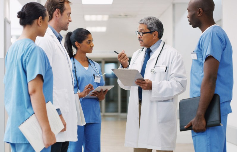 multi-ethnic group of doctors conversing in hallway
