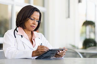 female doctor reading on tablet device