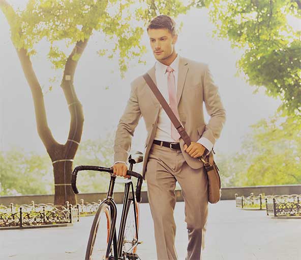 Man in suit walking while pushing bicycle