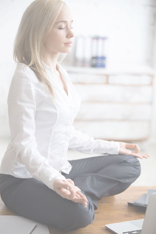 Businesswoman doing yoga in her office