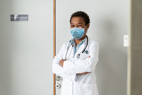 doctor posing in white coat and wearing a mask