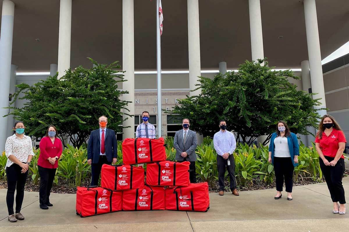 group standing with pyramid of CPR kits