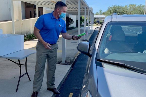 man giving paperwork to person in car