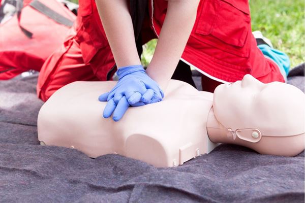person practicing hands only CPR on dummy