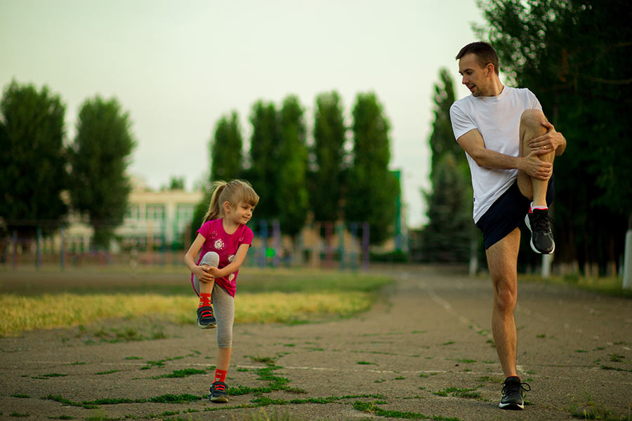 dad and daughter stretch before a run