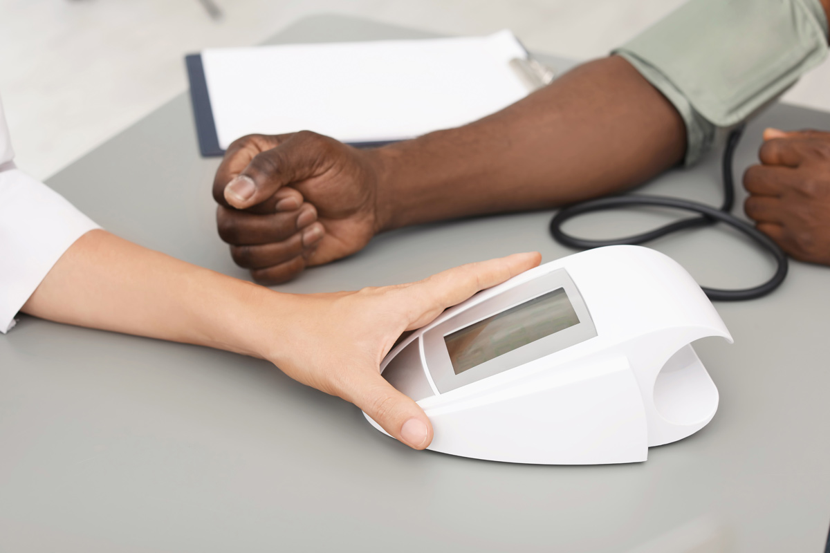 person's arm with blood pressure cuff being tested