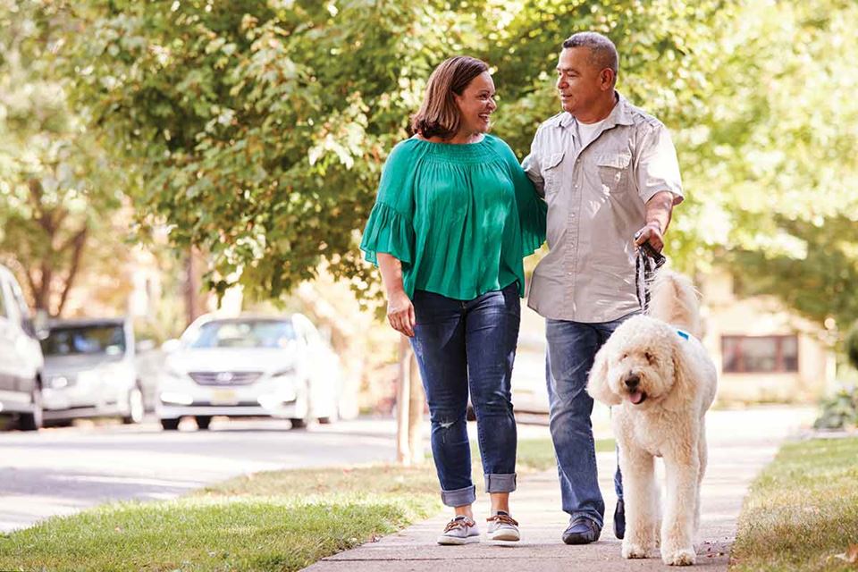 couple walking dog on path
