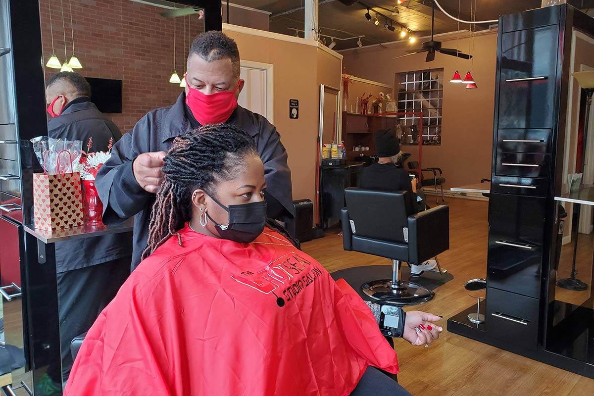 barber doing the hair of woman in chair