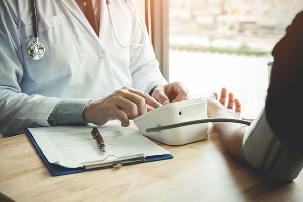 medical professional testing person's blood pressure