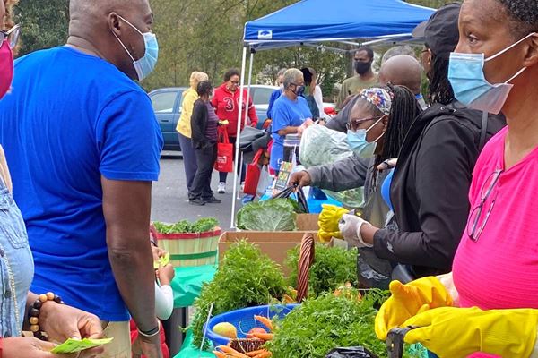 people in masks at farmers' market