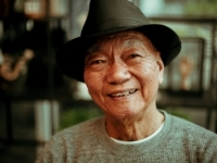 A man wearing a hat looking at the camera smiling