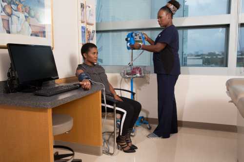Woman getting blood pressure checked by a nurse