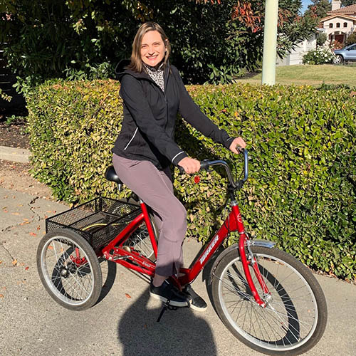 Ann Koenig smiling on a bicycle