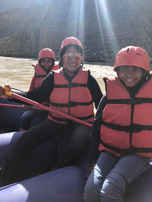 Dr. Neelima Vallurupallo and her two kids smiling while water rafting