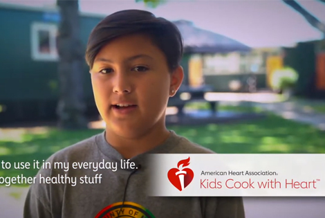 child giving a testimonial about Kids Cook with Heart, logo for the Kids Cook with Heart program overlayed in the bottom right corner