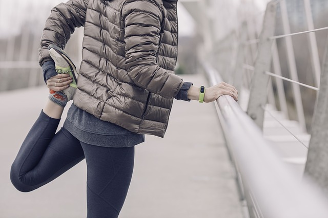 woman stretching on a bridge in winter before a run