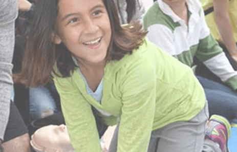 Child smiling while learning Hands-Only CPR