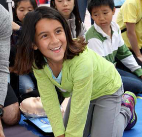 smiling child learning CPR